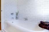 bathtub in room with white tile