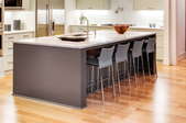 large kitchen island with sink and chairs over wooden floors