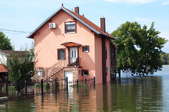 A pink house surrounded by floodwaters.