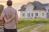 couple looking at a house on a dirt road