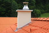 A red tile roof with a chimney and roof flashing. 