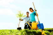 Cheerful young couple planting a tree.