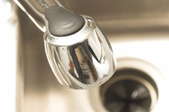 An aerial view of a stainless steel sink with a faucet and drain. 