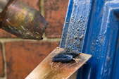 Cupboard door blue paint removal close up.