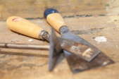 A putty knife and chisel used to remove masonry paint.