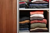 closet sliding door open, exposing folded clothes