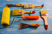 Paint rollers on a rustic surface.
