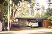 An open carport made from wood and painted a shade of blue.