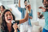 young friends singing karaoke together at a party