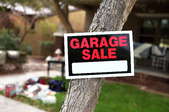 A garage sale sign on a tree.