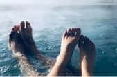 male and female feet in a steaming hot tub
