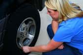 A professional inspecting a vehicle's wheel.