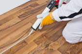 Silicone glue is applied on home flooring.