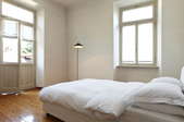 A spare bedroom painted white and filled with light.