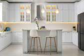 clean, modern kitchen with hanging lights and island with stools