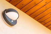 motion detector porch light on wall under wood ceiling