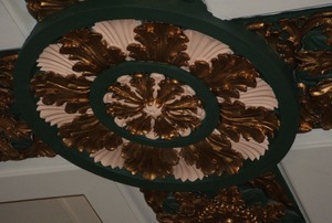 A green- and gold-painted ceiling medallion.