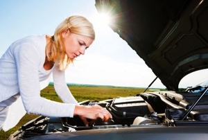 A young woman checks her oil.