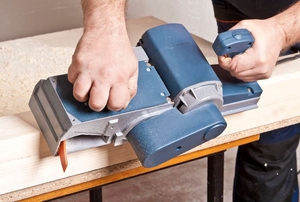 Carpenter with electric planer.