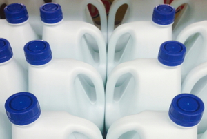 Several white bleach bottles sitting in rows.