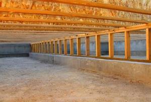 Looking down the length of an unfinished crawl space.