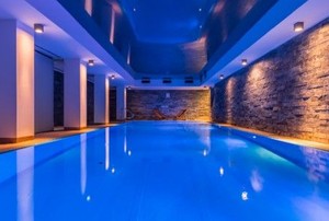 Indoor pool with side lighting on stone walls