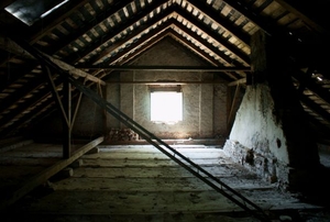 An empty attic with light coming through a window.