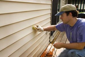 A man cleans siding.