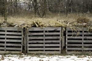 A trio of wood compost bins outside in the winter snow.
