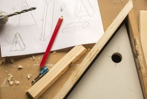 triangular birdhouse on a wooden workshop table