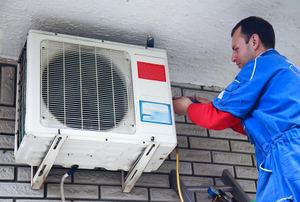 A man does air conditioner maintenance.