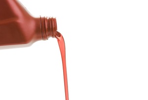 a copper-colored bottle pouring out reddish fluid