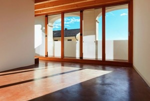 An empty room with a stained concrete floor.