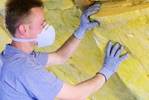 a man installs a sheet of insulation
