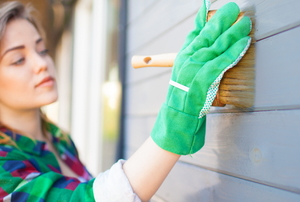woman painting house exterior siding