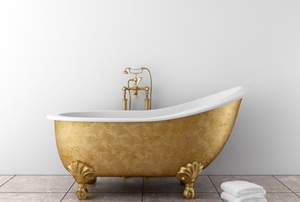 A fancy gold bathtub against a white wall.