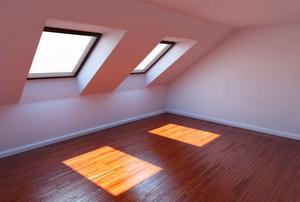 Windows projecting squares of light onto a wood-paneled in a finished attic.