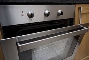 A built-in stove with the door ajar.