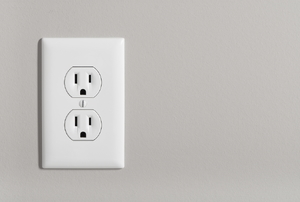 An outlet against a gray wall.