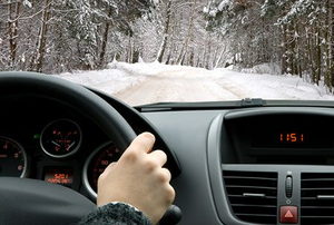 A drive down a snowy, icy road during winter.