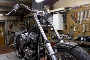 A motorcycle sitting inside a workshop.