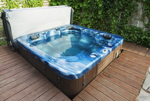 A hot tub outside on a wooden deck.