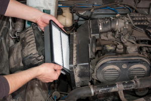 Person inserting a new air filter into an engine