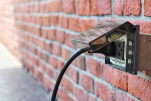 exterior outlet with plug on brick wall