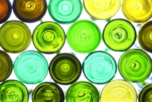 An assortment of colorful wine bottles lit from behind. 