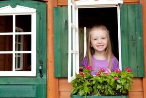 young girl looking out of playhouse window