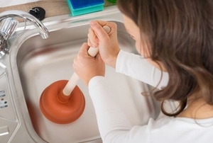 woman plunging a kitchen sink