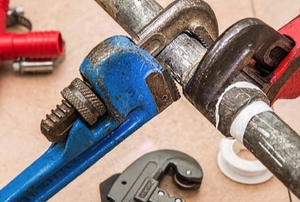 plumbing wrenches on a large pipe