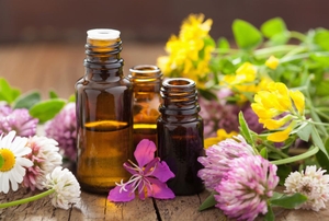 A trio of essential oils surrounded by flowers.