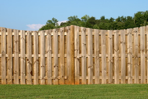 A wood fence on a grass lawn. 